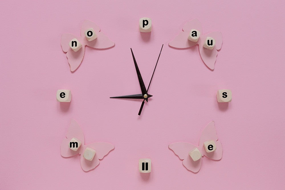 A pink clock with the word Menopause round the outside instead of numbers.